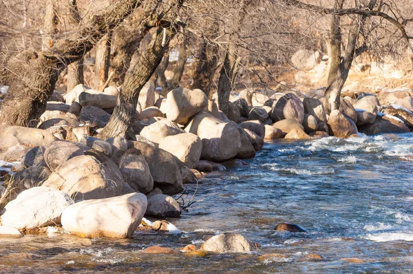 su küçük bir nehir erken ilkbahar akarsu. Bahar sahne. donmuş bir dere ile dağ manzarası