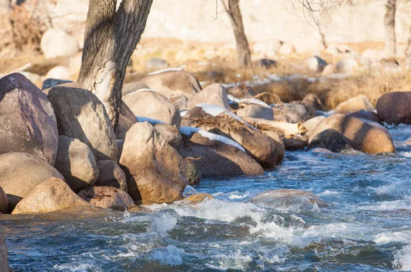 su küçük bir nehir erken ilkbahar akarsu. Bahar sahne. donmuş bir dere ile dağ manzarası
