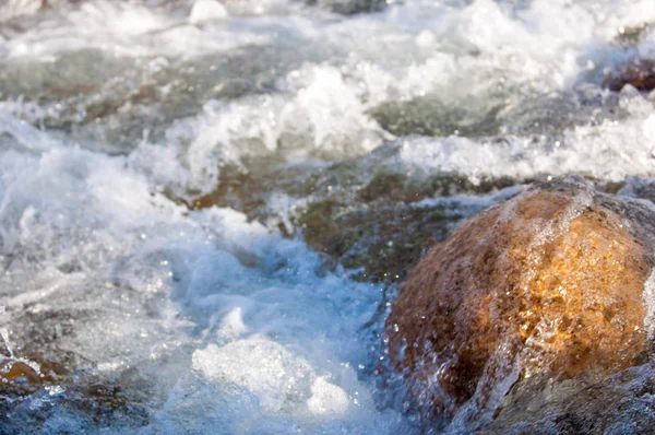 su küçük bir nehir erken ilkbahar akarsu. Bahar sahne. donmuş bir dere ile dağ manzarası