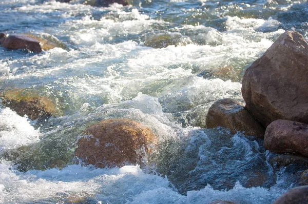 su küçük bir nehir erken ilkbahar akarsu. Bahar sahne. donmuş bir dere ile dağ manzarası