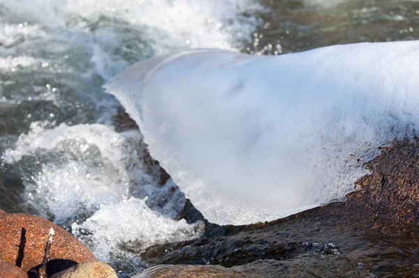 su küçük bir nehir erken ilkbahar akarsu. Bahar sahne. donmuş bir dere ile dağ manzarası