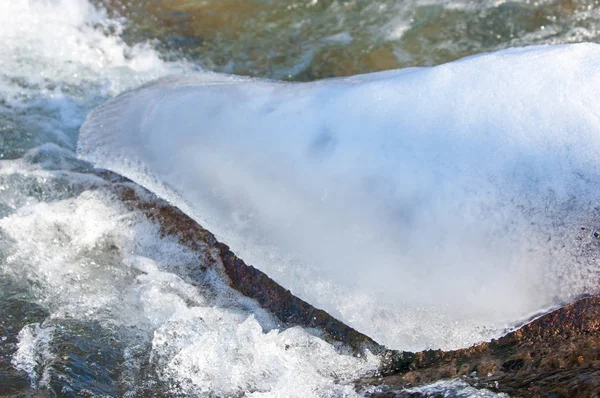 su küçük bir nehir erken ilkbahar akarsu. Bahar sahne. donmuş bir dere ile dağ manzarası