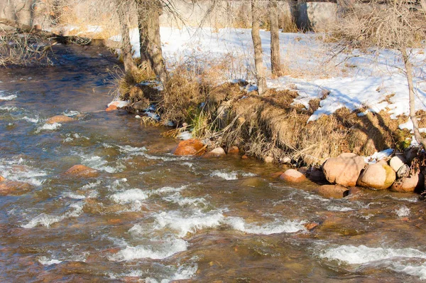 su küçük bir nehir erken ilkbahar akarsu. Bahar sahne. donmuş bir dere ile dağ manzarası