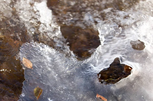 su küçük bir nehir erken ilkbahar akarsu. Bahar sahne. donmuş bir dere ile dağ manzarası