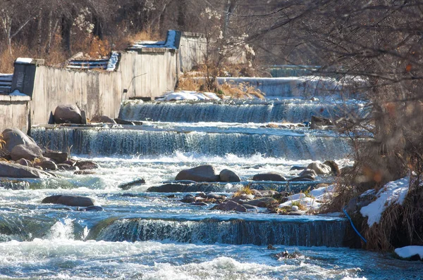 su küçük bir nehir erken ilkbahar akarsu. Bahar sahne. donmuş bir dere ile dağ manzarası