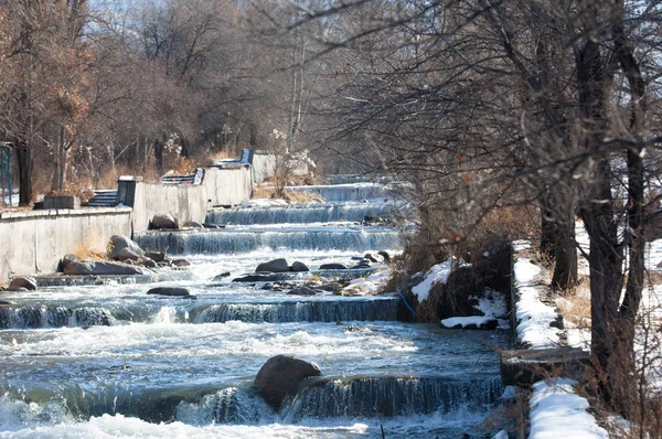 su küçük bir nehir erken ilkbahar akarsu. Bahar sahne. donmuş bir dere ile dağ manzarası