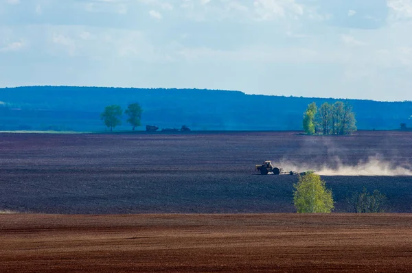 Alan sürülmüş, ekilen hububat. Bahar günü sürülmüş alana. Siyah toprak sürülmüş alan. Mavi gökyüzünde sürülmüş alan