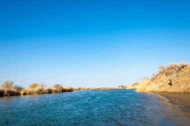 bahar bozkır nehirde. nehir sazlık ile büyümüş. saf zümrüt sudur