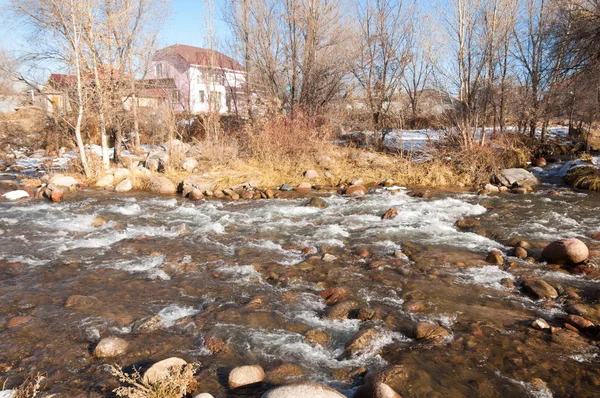 su küçük bir nehir erken ilkbahar akarsu. Bahar sahne. donmuş bir dere ile dağ manzarası