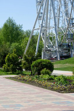 Şehir Parkı içinde dönme dolap. Kırmızı Dev dönme dolap ile berrak mavi gökyüzünün yarısı. Büyük vintage dalgalanmalar 