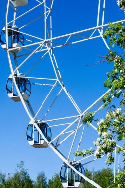 Şehir Parkı içinde dönme dolap. Kırmızı Dev dönme dolap ile berrak mavi gökyüzünün yarısı. Büyük vintage dalgalanmalar 