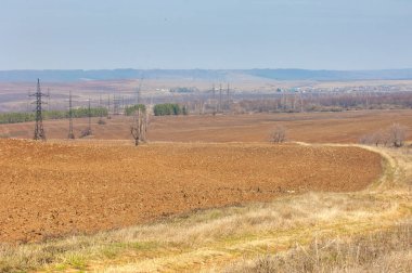 Bahar manzara. Taze sürülmüş alan. engebeli arazi. ağaçların yaprakları olmadan. Çok renkli bahar ağaçları. Geçen yılki kış kar kalan. Son kar.