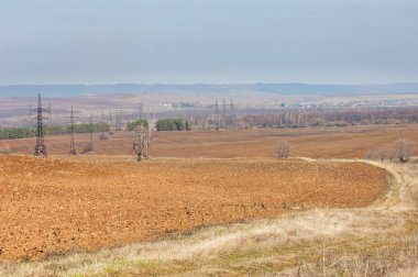 Bahar manzara. Taze sürülmüş alan. engebeli arazi. ağaçların yaprakları olmadan. Çok renkli bahar ağaçları. Geçen yılki kış kar kalan. Son kar.
