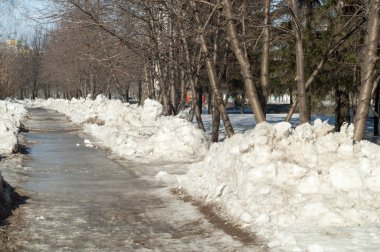 Doku, arka plan, desen. Bahar kar erir. Sıcak bir sezon, Bahar başında. Şehrin hafif sabah güneş ışığı ile yere eriyen kar.