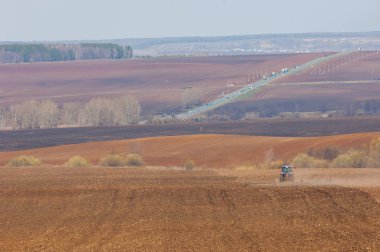 2017 05 01 Tataristan Rusya işleri zamanında başlatılan alan bahar ve yönetmeliklerine uygun olarak vardır. Traktör alan pulluklar. Tepelik alanlar taze düşmüş. sıcak Bahar güneşi. sezon Ekim