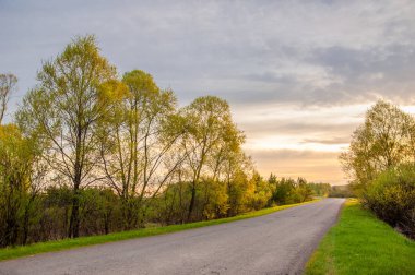 Bahar peyzaj, gündoğumu gündoğumu. Köy yolunda, bir yol ile kırsal manzara.