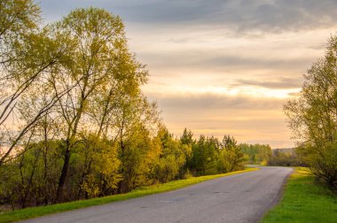 Bahar peyzaj, gündoğumu gündoğumu. Köy yolunda, bir yol ile kırsal manzara.