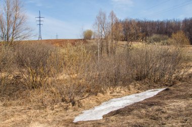 Bahar manzara. Taze sürülmüş alan. engebeli arazi. ağaçların yaprakları olmadan. Çok renkli bahar ağaçları. Geçen yılki kış kar kalan. Son kar.