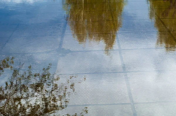 ファブリックのテクスチャ背景 春の風景 歩道に雪解け水の水たまり — ストック写真