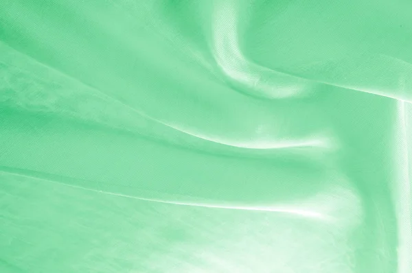 Background texture, pattern. Green silk background with some soft folds and highlights. green background abstract cloth or liquid wave illustration of wavy folds of silk texture satin