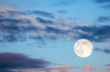 Gün batımında akşam manzara. Gökyüzünde dolunay ile. Şiddetli fırtına bulutları pastel tonları ile.
