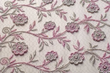 Doku, arka plan, desen. Pembe dantel çiçek üzerinde beyaz bir arka plan ile dekore edilmiştir. Arka planını çiçekler ile dekore edilmiş pembe dantel kumaş