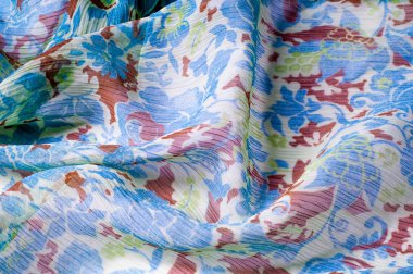 Doku, arka plan, desen. Kumaş krep de chine. Mavi beyaz pişmiş toprak yeşil. Kumaş üzerine boyalı çiçekler vardır. Soyut çizim