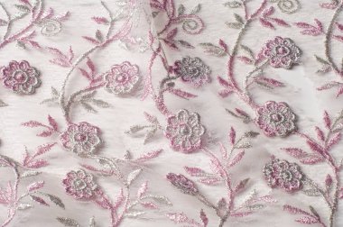 Doku, arka plan, desen. Pembe dantel çiçek üzerinde beyaz bir arka plan ile dekore edilmiştir. Arka planını çiçekler ile dekore edilmiş pembe dantel kumaş