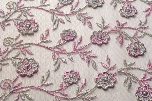 Doku, arka plan, desen. Pembe dantel çiçek üzerinde beyaz bir arka plan ile dekore edilmiştir. Arka planını çiçekler ile dekore edilmiş pembe dantel kumaş