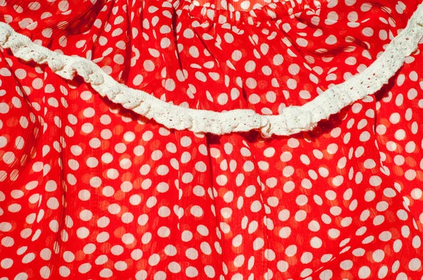 Texture, background, pattern. Women's dress. Cotton fabric is red with a green pea