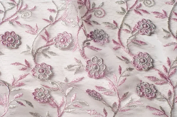 Doku, arka plan, desen. Pembe dantel çiçek üzerinde beyaz bir arka plan ile dekore edilmiştir. Arka planını çiçekler ile dekore edilmiş pembe dantel kumaş