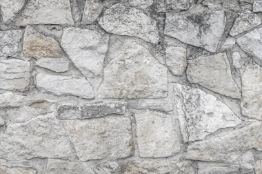 Doku, arka plan, desen. Eski granit taşlar. Eski bir taş duvar. Taştan bir duvar dokusu. Bir eski gri taş ve kum taşı doku kökenli tuğla duvar.