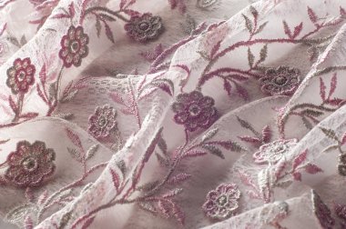 Doku, arka plan, desen. Pembe dantel çiçek üzerinde beyaz bir arka plan ile dekore edilmiştir. Arka planını çiçekler ile dekore edilmiş pembe dantel kumaş