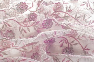 Doku, arka plan, desen. Pembe dantel çiçek üzerinde beyaz bir arka plan ile dekore edilmiştir. Arka planını çiçekler ile dekore edilmiş pembe dantel kumaş
