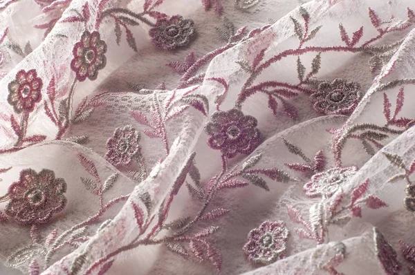 Doku, arka plan, desen. Pembe dantel çiçek üzerinde beyaz bir arka plan ile dekore edilmiştir. Arka planını çiçekler ile dekore edilmiş pembe dantel kumaş