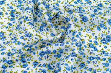 Arka plan doku, desen. küçük mavi çiçekler ile ince pamuklu kumaş. Kumaş zeytin yeşil çiçek sapları ve küçük mavi - aqua çiçek karışımı olan beyaz bir arka plana sahiptir. 