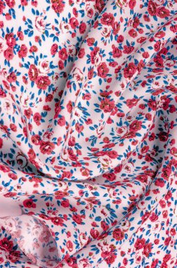 Arka plan doku, küçük kırmızı çiçekli ince pamuklu kumaş. Orta ağırlıkta, kapitone bez veya kumaş pamuk kumaş küçük yaz çiçek, pembe, mor, sarı, yeşil yapraklar, beyaz arka plan üzerinde