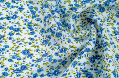 Arka plan doku, desen. küçük mavi çiçekler ile ince pamuklu kumaş. Kumaş zeytin yeşil çiçek sapları ve küçük mavi - aqua çiçek karışımı olan beyaz bir arka plana sahiptir. 