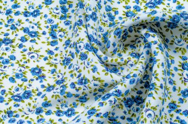 Arka plan doku, desen. küçük mavi çiçekler ile ince pamuklu kumaş. Kumaş zeytin yeşil çiçek sapları ve küçük mavi - aqua çiçek karışımı olan beyaz bir arka plana sahiptir. 