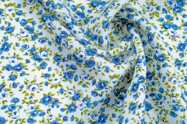 Arka plan doku, desen. küçük mavi çiçekler ile ince pamuklu kumaş. Kumaş zeytin yeşil çiçek sapları ve küçük mavi - aqua çiçek karışımı olan beyaz bir arka plana sahiptir. 