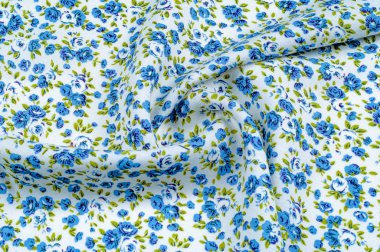 Arka plan doku, desen. küçük mavi çiçekler ile ince pamuklu kumaş. Kumaş zeytin yeşil çiçek sapları ve küçük mavi - aqua çiçek karışımı olan beyaz bir arka plana sahiptir. 