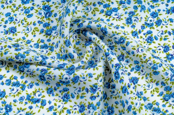 Arka plan doku, desen. küçük mavi çiçekler ile ince pamuklu kumaş. Kumaş zeytin yeşil çiçek sapları ve küçük mavi - aqua çiçek karışımı olan beyaz bir arka plana sahiptir. 
