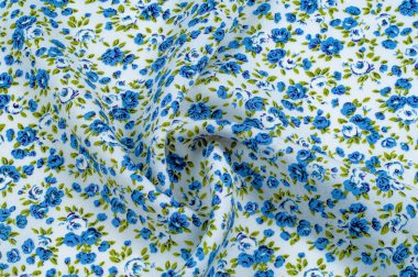 Arka plan doku, desen. küçük mavi çiçekler ile ince pamuklu kumaş. Kumaş zeytin yeşil çiçek sapları ve küçük mavi - aqua çiçek karışımı olan beyaz bir arka plana sahiptir. 