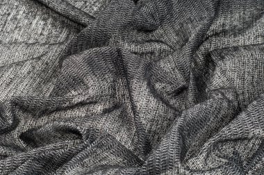 kumaş gri beyaz ekler ile altın ince beyaz iplik siyah bir arka plan üzerinde çizilir ve daha kalın beyaz iplikler, altın, küçük bir miktar ile bükülmüş neredeyse gölcüğününiçine görünüm oluşturmak metalik siyah