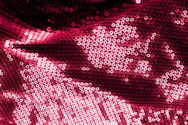 Arka plan doku, desen. İle kumaş kırmızı bordo. Bu Neon pembe birleşiyor payetler bak. Yuvarlak neon pembe birleşiyor payetler yanardöner bir sheen ile şeffaf mor bir kafes arasında örtüşüyor.