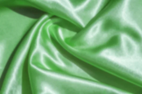 The blur is gaussian for designers. Texture, fabric, background. Abstract background of luxurious fabric or liquid waves or wavy grunge crease silk satin texture of velvet material . green