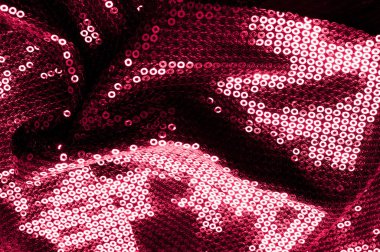 Arka plan doku, desen. İle kumaş kırmızı bordo. Bu Neon pembe birleşiyor payetler bak. Yuvarlak neon pembe birleşiyor payetler yanardöner bir sheen ile şeffaf mor bir kafes arasında örtüşüyor.