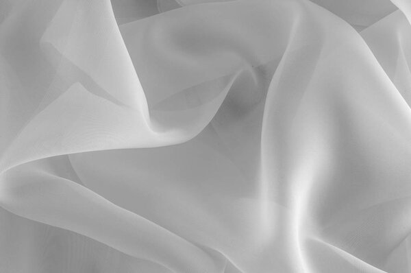 Texture, background, pattern. Silk fabric is transparent, white in color. Abstract soft chiffon texture background. Soft white chiffon with curve and wave