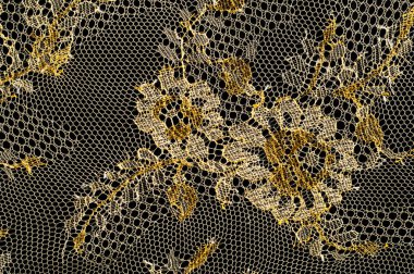 Resmi doku arka planı, dekoratif altın dantel desenli. Altın vintage dantelli arka plan. Siyah bir zemin üzerine altın dantel. Spandex, makro. Dantelli dekoratif çiçek desenli.