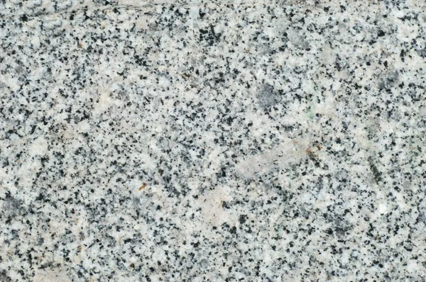 Texture, background, pattern. Granite stone. Padang Gray light gray granite with pronounced specks of black, quartz color, mined in Fujian province in the southeast of China.